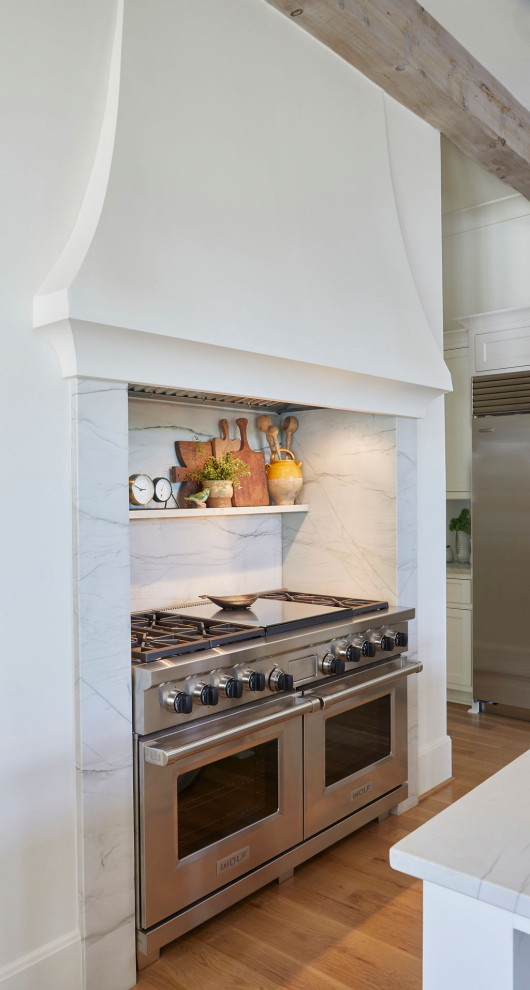 Eat-in kitchen - large transitional l-shaped medium tone wood floor eat-in kitchen idea in Birmingham with a farmhouse sink, recessed-panel cabinets, white cabinets, stainless steel appliances and an island
