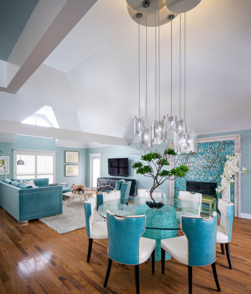 Example of a mid-sized island style medium tone wood floor and brown floor great room design in New Orleans with blue walls, a standard fireplace and a tile fireplace