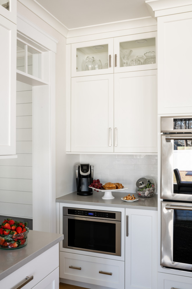 Inspiration for a transitional kitchen remodel in Providence with an undermount sink, shaker cabinets, quartzite countertops, subway tile backsplash and an island