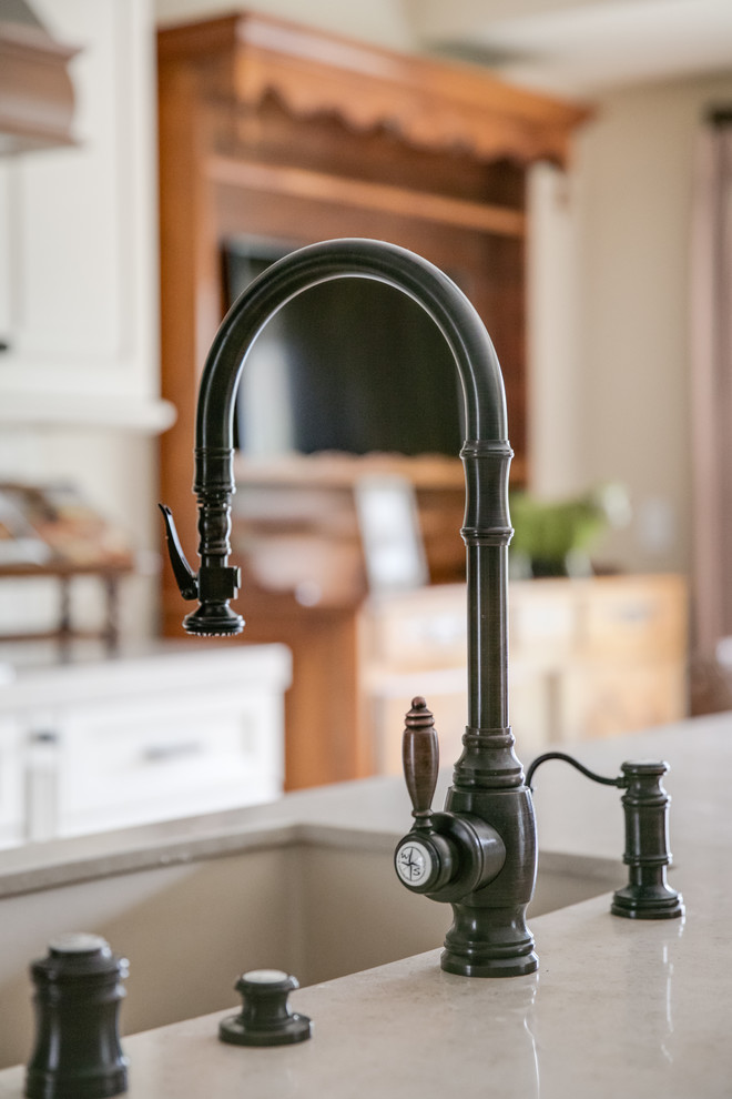 Mid-sized elegant single-wall dark wood floor open concept kitchen photo in San Francisco with an undermount sink, raised-panel cabinets, white cabinets, quartzite countertops, beige backsplash, ceramic backsplash, stainless steel appliances and an island