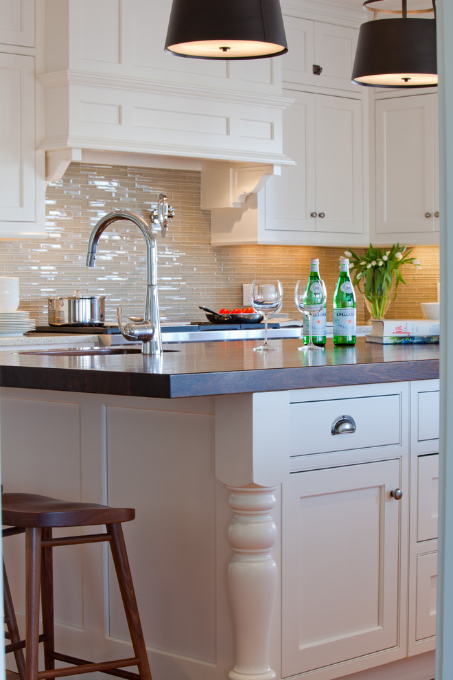Inspiration for a traditional u-shaped kitchen in Boston with a farmhouse sink, beaded inset cabinets, white cabinets, beige splashback, stainless steel appliances, with island and white benchtop.
