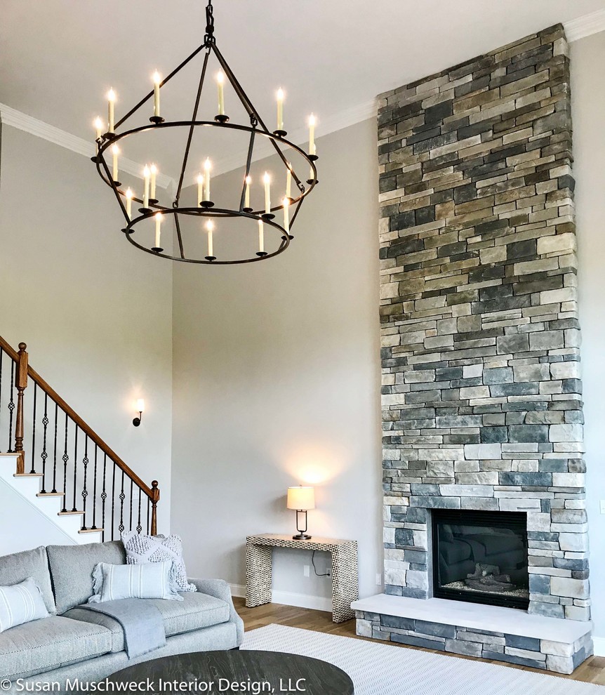 Example of a large transitional open concept light wood floor home design design with white walls, a standard fireplace and a stone fireplace