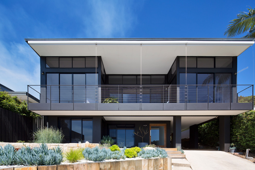This is an example of a contemporary two-storey black house exterior in Sydney with a flat roof.