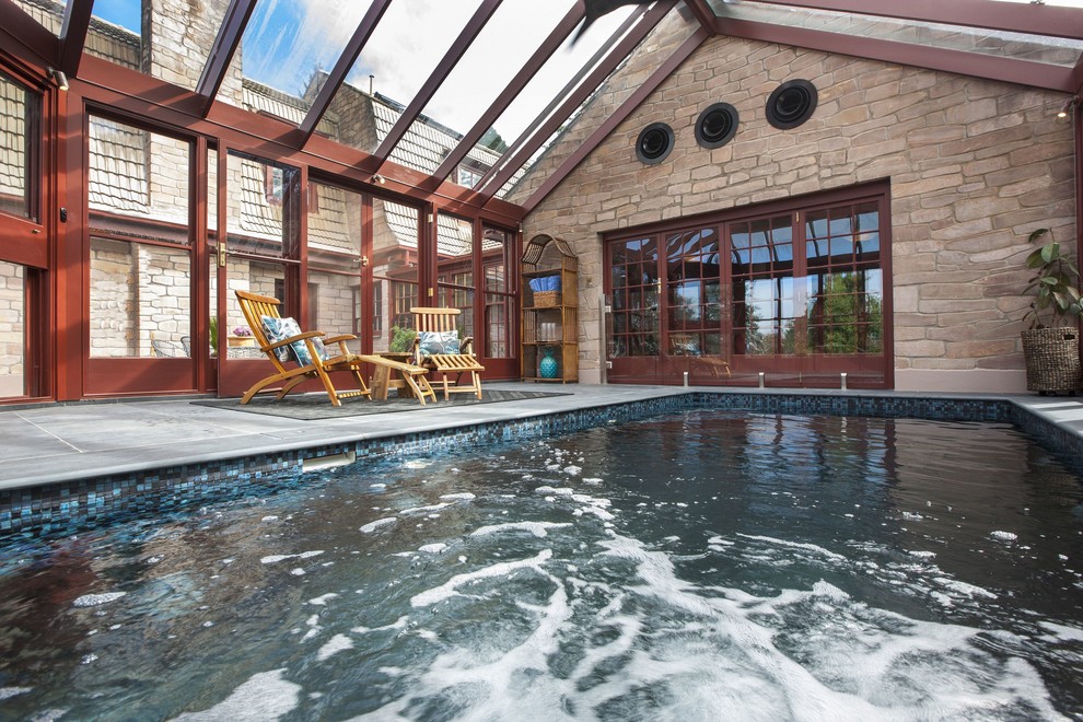 Photo of a modern indoor rectangular pool in Adelaide with a hot tub and natural stone pavers.