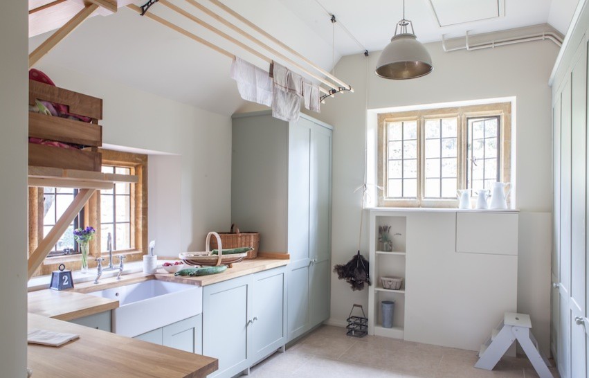 This is an example of a country laundry room in Oxfordshire with beige benchtop.