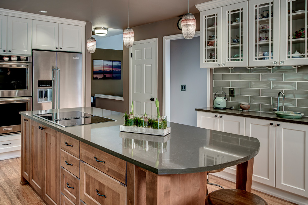 Mid-sized transitional kitchen in Seattle with an undermount sink, recessed-panel cabinets, white cabinets, quartz benchtops, green splashback, ceramic splashback, stainless steel appliances, medium hardwood floors, with island, red floor and brown benchtop.