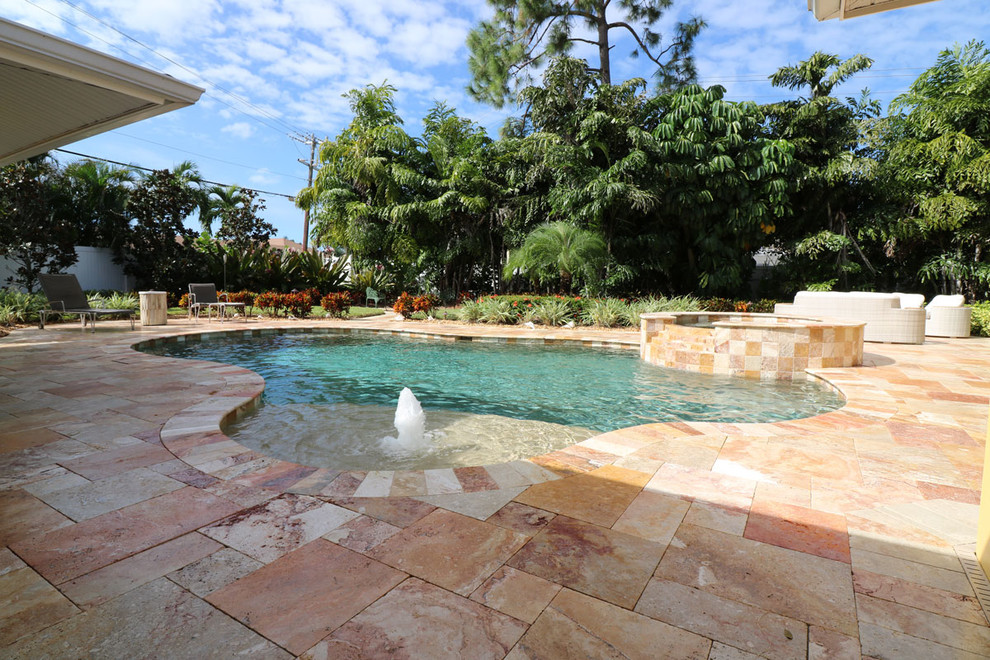 Large transitional backyard tile and custom-shaped hot tub photo in Miami