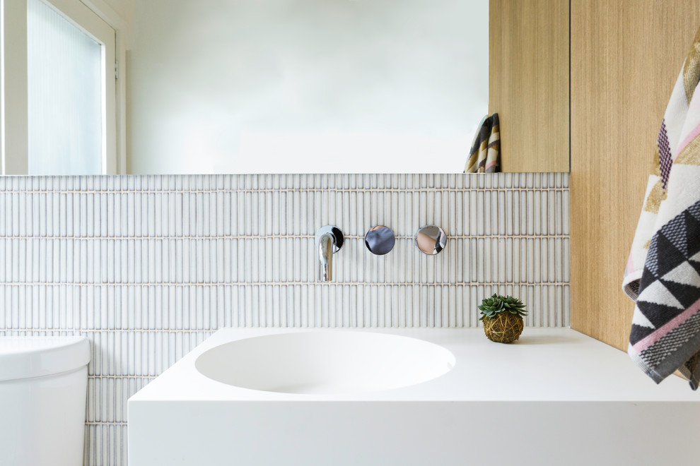 Photo of a mid-sized contemporary 3/4 bathroom in Melbourne with beaded inset cabinets, light wood cabinets, a corner tub, an open shower, white tile, subway tile, a drop-in sink, solid surface benchtops, an open shower and white benchtops.