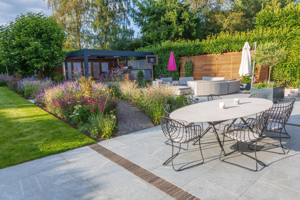 Mid-sized contemporary backyard and ground level deck in Buckinghamshire with a pergola.