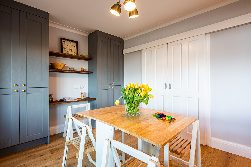 Foto di una sala da pranzo aperta verso la cucina tradizionale di medie dimensioni con pavimento marrone