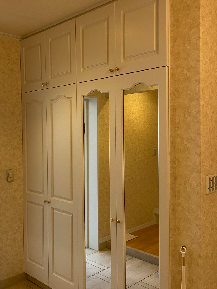 Immagine di un corridoio con pareti beige, parquet chiaro, una porta scorrevole, una porta bianca, soffitto in carta da parati e carta da parati