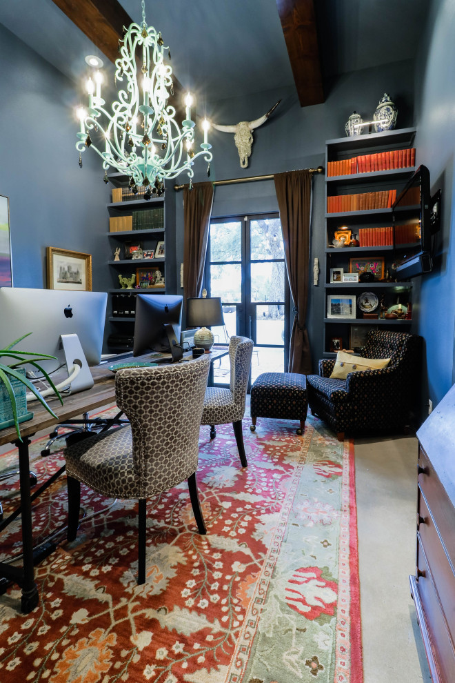 Imagen de despacho actual de tamaño medio con paredes azules, suelo de cemento, escritorio independiente, suelo gris y vigas vistas