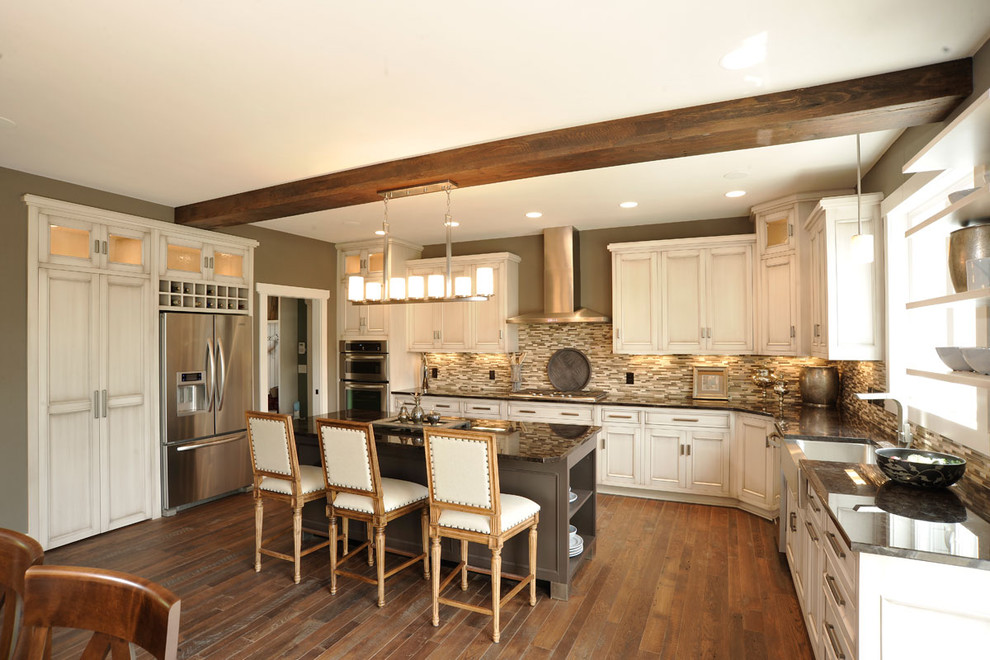 Traditional u-shaped eat-in kitchen in Columbus with stainless steel appliances, a farmhouse sink, beaded inset cabinets, distressed cabinets, brown splashback, mosaic tile splashback, dark hardwood floors, with island, multi-coloured benchtop and exposed beam.
