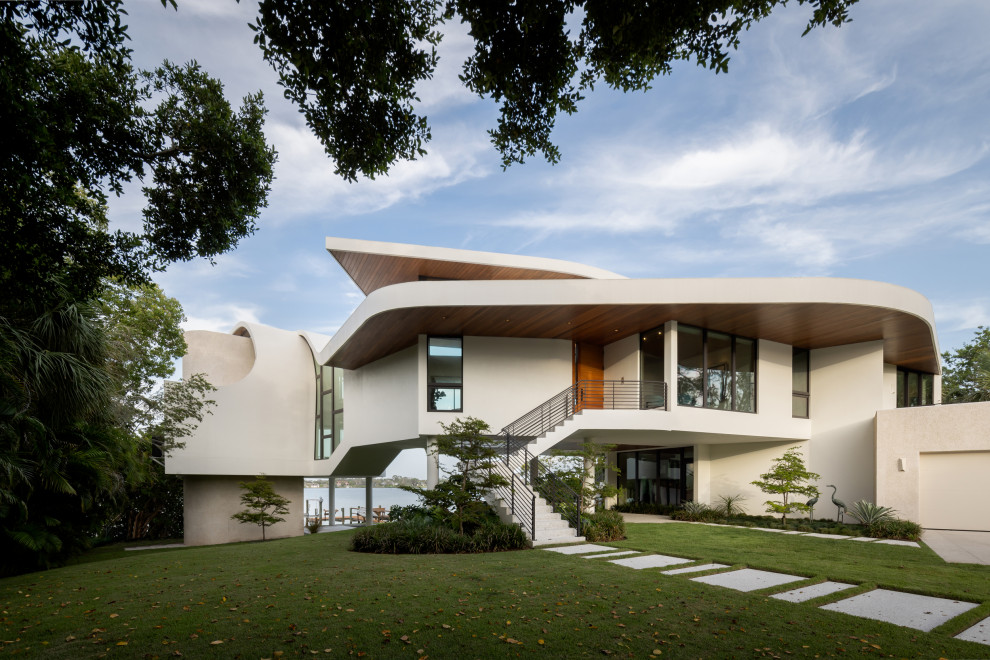 Diseño de fachada de casa blanca y blanca minimalista grande de tres plantas con revestimiento de estuco y tejado de varios materiales