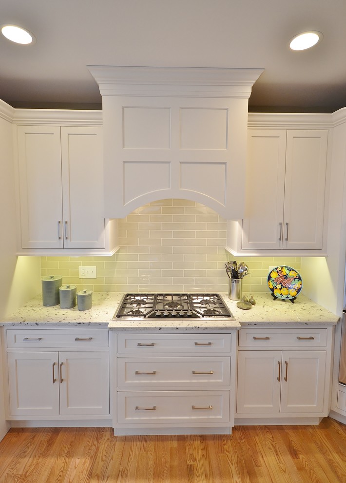 Large traditional l-shaped eat-in kitchen in Philadelphia with an undermount sink, flat-panel cabinets, white cabinets, granite benchtops, beige splashback, subway tile splashback, stainless steel appliances, light hardwood floors and with island.