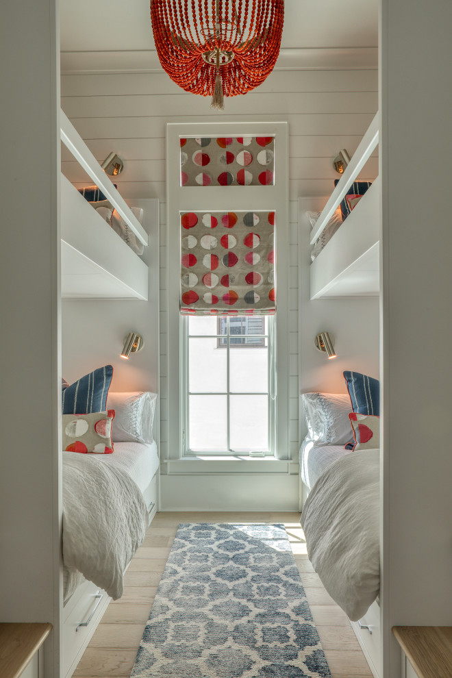 Aménagement d'une petite chambre d'enfant bord de mer avec un mur blanc, parquet clair, un sol beige et du lambris de bois.