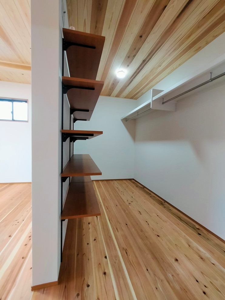 Идея дизайна: гардеробная комната среднего размера, унисекс с паркетным полом среднего тона, коричневым полом и деревянным потолком