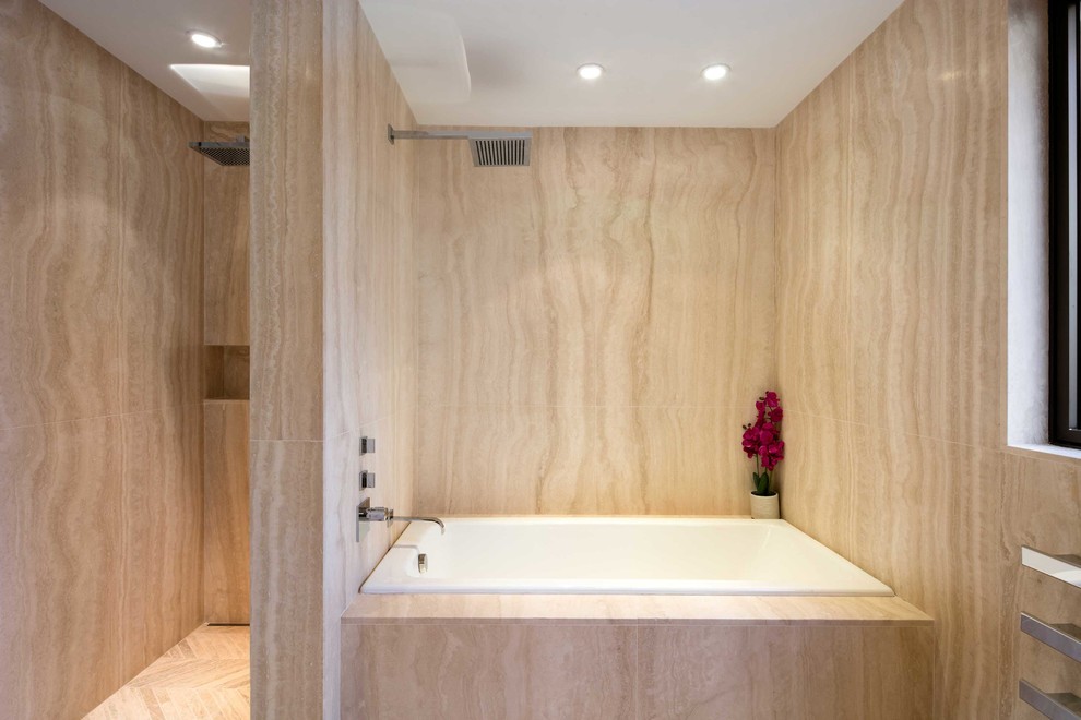 This is an example of a mid-sized contemporary bathroom in New York with a drop-in tub, beige tile, stone slab, marble floors and with a sauna.