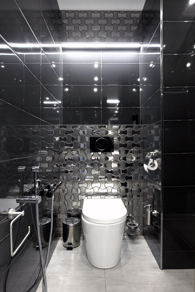 Photo of a small contemporary powder room in Moscow with a one-piece toilet, black tile, black walls and ceramic floors.