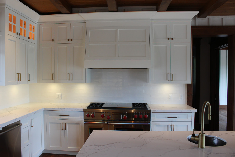 Inspiration for a large rustic u-shaped dark wood floor, brown floor and wood ceiling eat-in kitchen remodel in Toronto with a farmhouse sink, shaker cabinets, white cabinets, quartz countertops, white backsplash, subway tile backsplash, stainless steel appliances, an island and white countertops