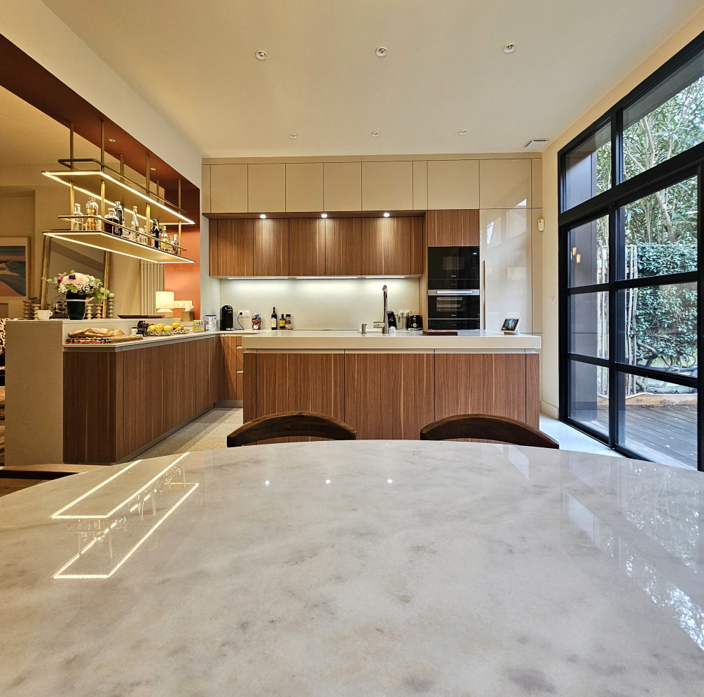 This is an example of a large midcentury l-shaped breakfast bar in Bordeaux with an integrated sink, beaded cabinets, medium wood cabinets, engineered stone countertops, beige splashback and beige worktops.
