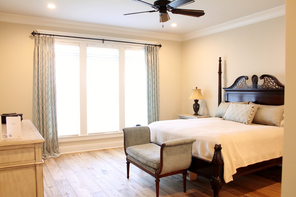 This is an example of a master bedroom in Other with beige walls, light hardwood floors and no fireplace.