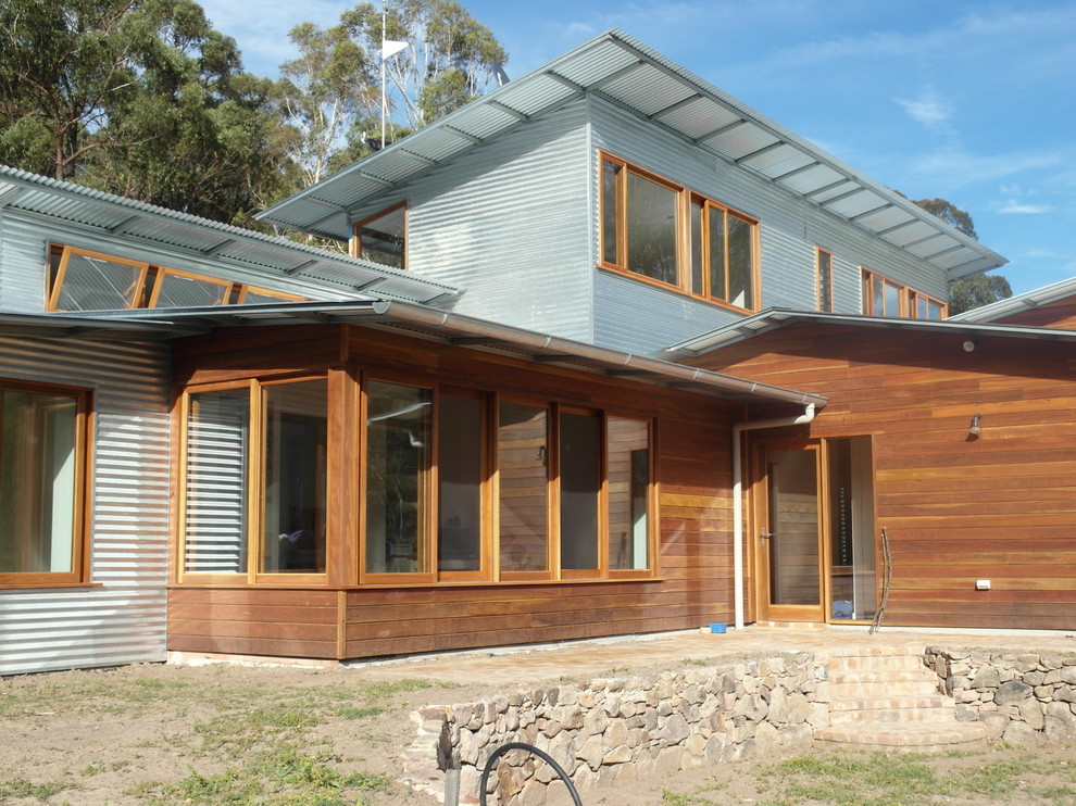 This is an example of a mid-sized eclectic two-storey exterior in Sydney with metal siding.