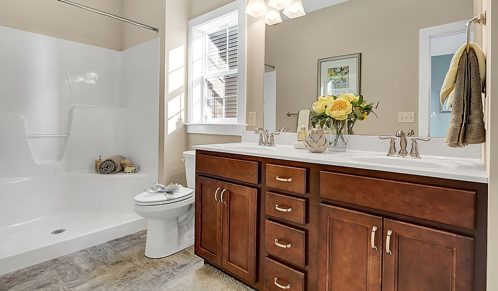 This is an example of a mid-sized transitional master bathroom in Other with recessed-panel cabinets, dark wood cabinets, an alcove shower, a two-piece toilet, gray tile, beige walls, ceramic floors, an integrated sink and solid surface benchtops.