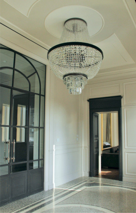 Design ideas for a large traditional foyer in Milan with white walls, terrazzo floors and a gray front door.