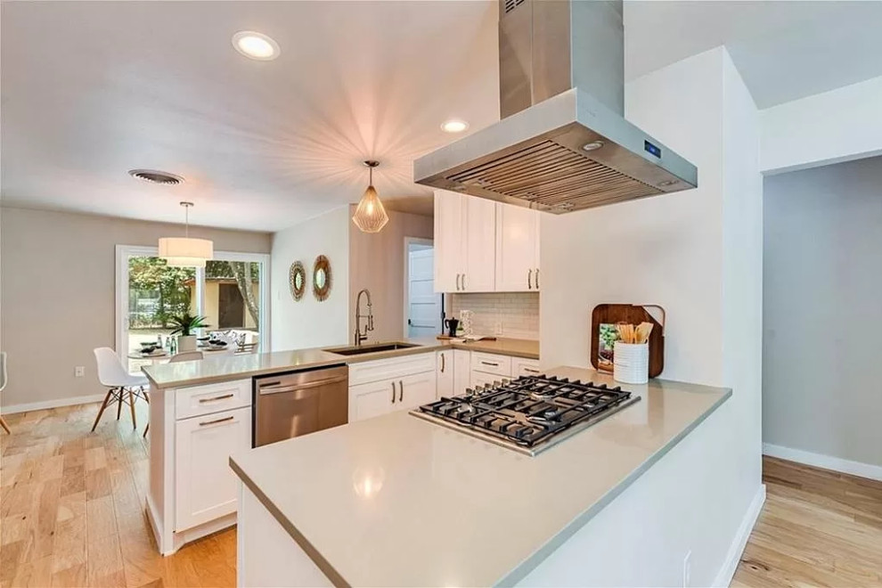 Inspiration for a small transitional u-shaped light wood floor kitchen remodel in Austin with white cabinets, quartz countertops, white backsplash and beige countertops