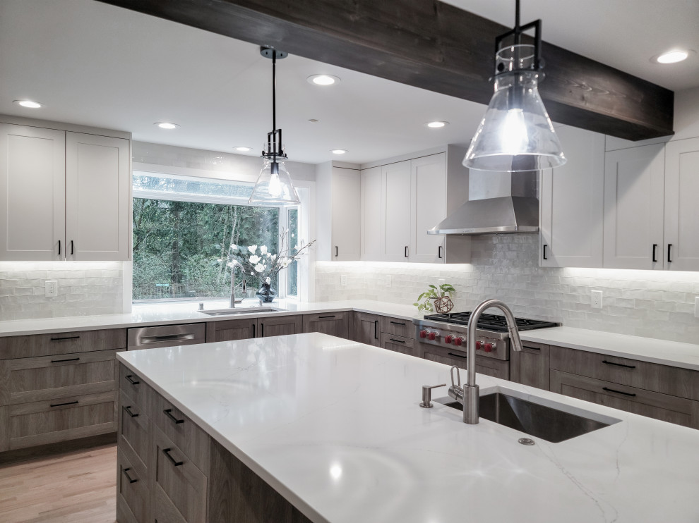 Inspiration for a large transitional l-shaped light wood floor, beige floor and exposed beam eat-in kitchen remodel in Seattle with a single-bowl sink, shaker cabinets, medium tone wood cabinets, quartz countertops, white backsplash, ceramic backsplash, stainless steel appliances, an island and white countertops