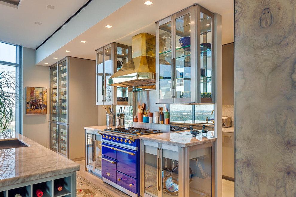 Inspiration for a large contemporary l-shaped separate kitchen in Austin with an undermount sink, glass-front cabinets, mirror splashback, with island, stainless steel cabinets, marble benchtops, metallic splashback, coloured appliances, light hardwood floors and brown floor.