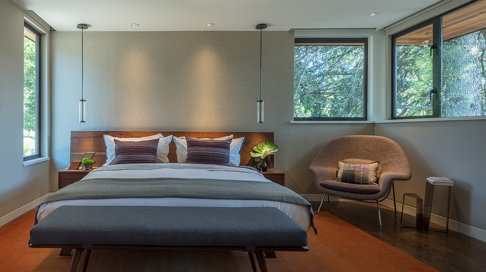 Large midcentury master bedroom in San Francisco with grey walls, medium hardwood floors and orange floor.