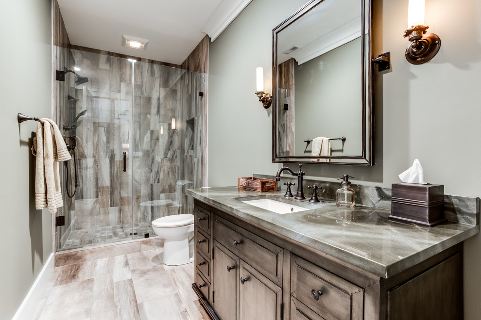 Photo of a mid-sized arts and crafts 3/4 bathroom in DC Metro with raised-panel cabinets, distressed cabinets, an open shower, a two-piece toilet, beige tile, cement tile, grey walls, ceramic floors, a drop-in sink and concrete benchtops.