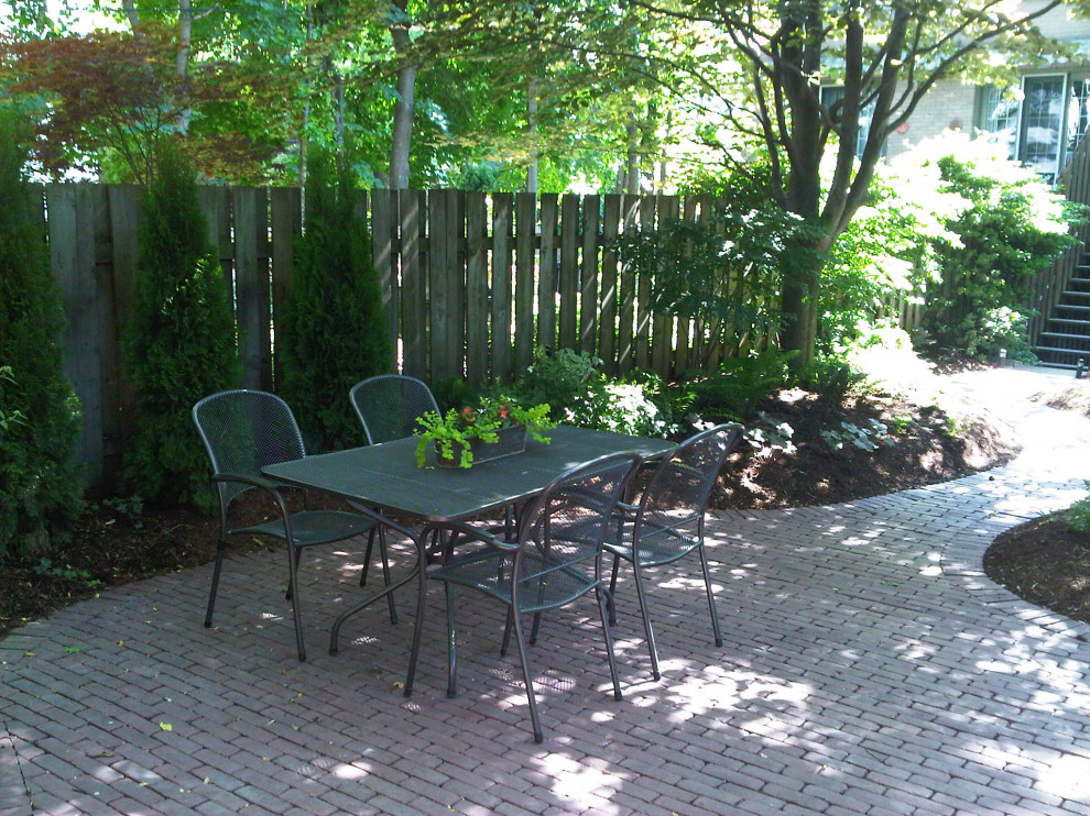 Mid-sized backyard shaded garden in Toronto with with flowerbed and brick pavers for summer.