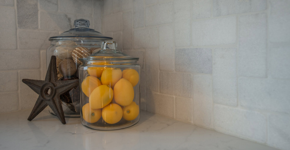 Foto di una cucina design di medie dimensioni con lavello sottopiano, ante di vetro, ante beige, elettrodomestici in acciaio inossidabile e pavimento in legno massello medio