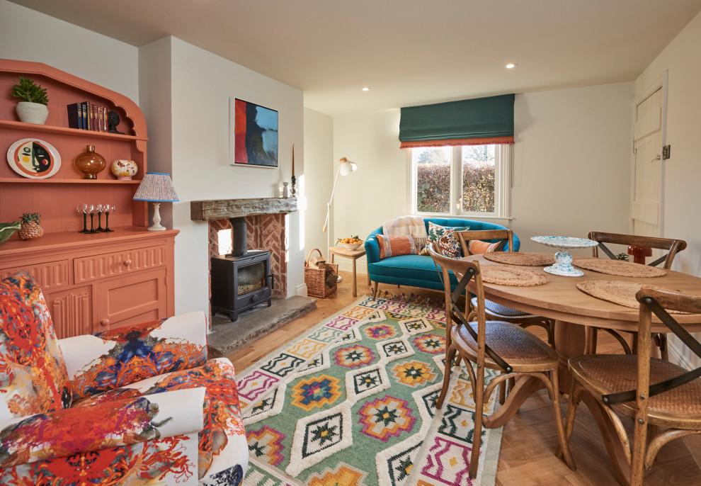Idee per un soggiorno classico con pareti beige, pavimento in legno massello medio, stufa a legna e pavimento marrone