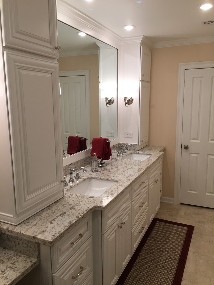 Inspiration for a mid-sized traditional master bathroom in New Orleans with raised-panel cabinets, white cabinets, a corner shower, orange walls, ceramic floors, an undermount sink, granite benchtops, beige floor, a hinged shower door and grey benchtops.