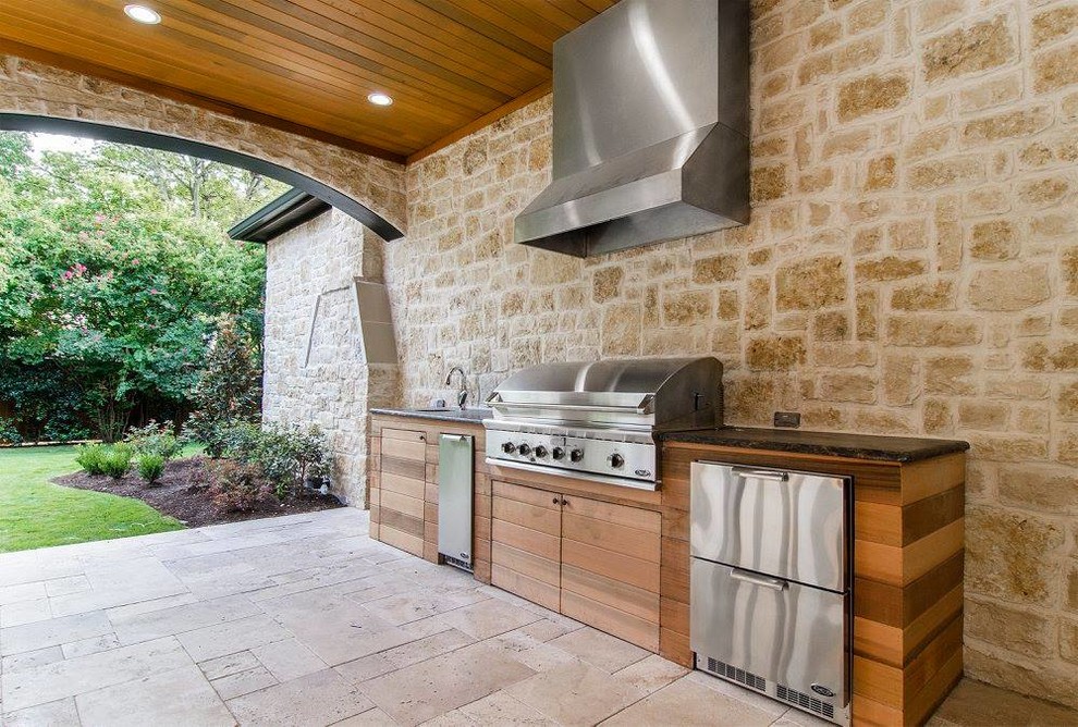 This is an example of a mid-sized contemporary backyard patio in Dallas with an outdoor kitchen, tile and a roof extension.