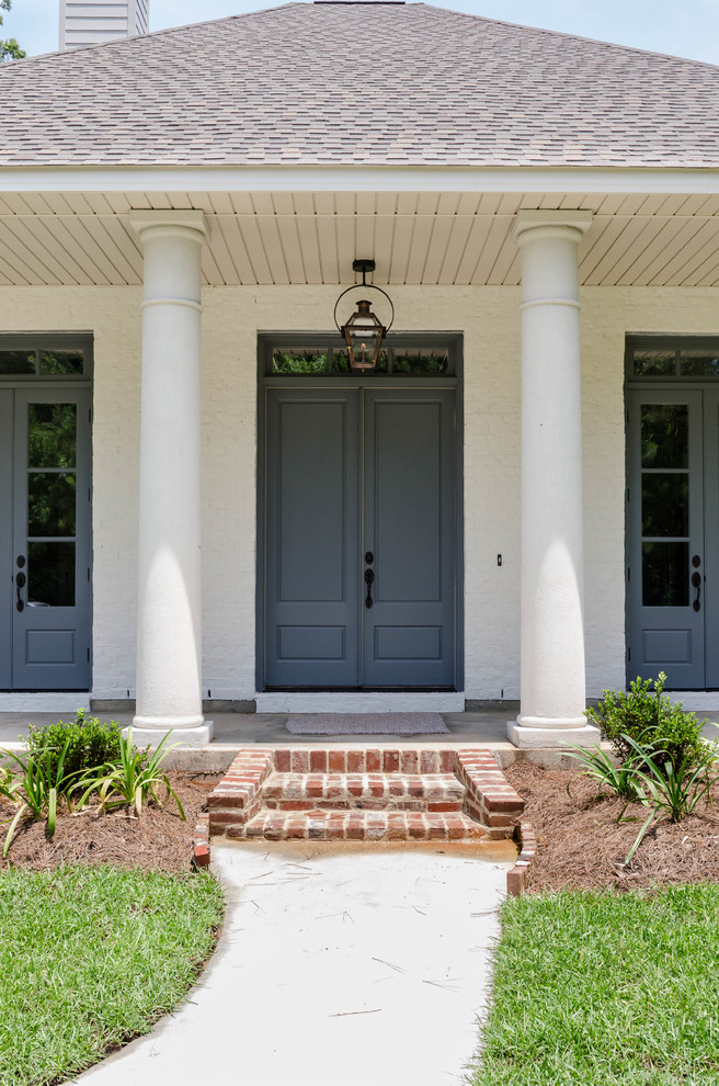 Design ideas for a mid-sized one-storey brick white exterior in New Orleans.