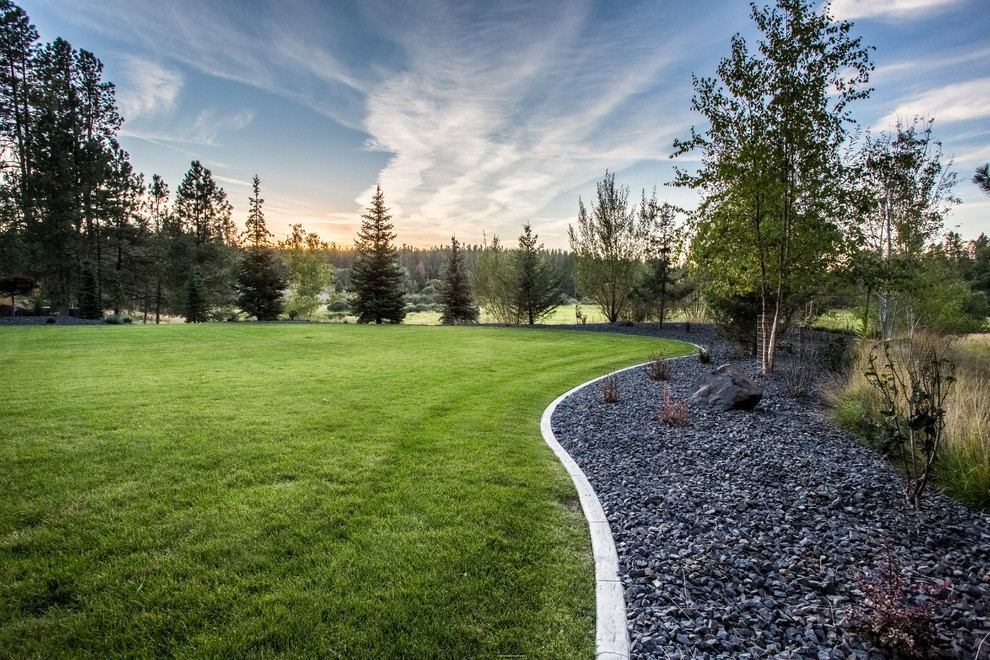 Expansive country sloped garden in Seattle with a retaining wall and concrete pavers.