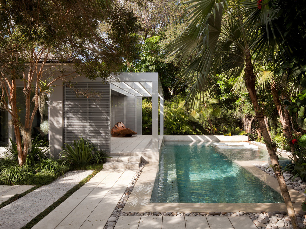This is an example of a modern lap pool in Miami with a pool house.