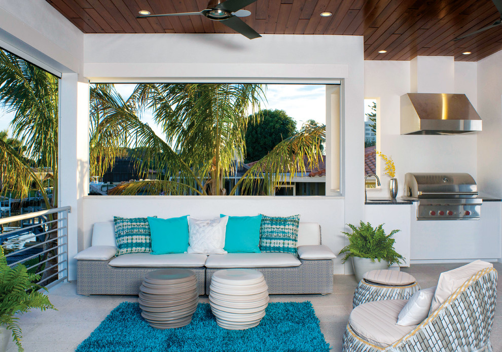 Inspiration for a transitional patio in Miami with an outdoor kitchen, concrete pavers and a roof extension.
