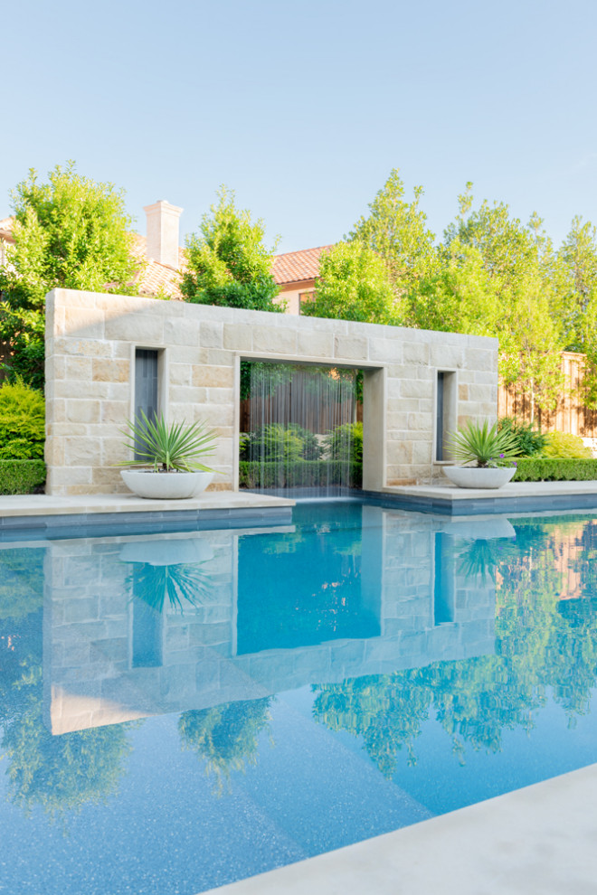 Photo of a large modern backyard rectangular pool in Dallas with decking.