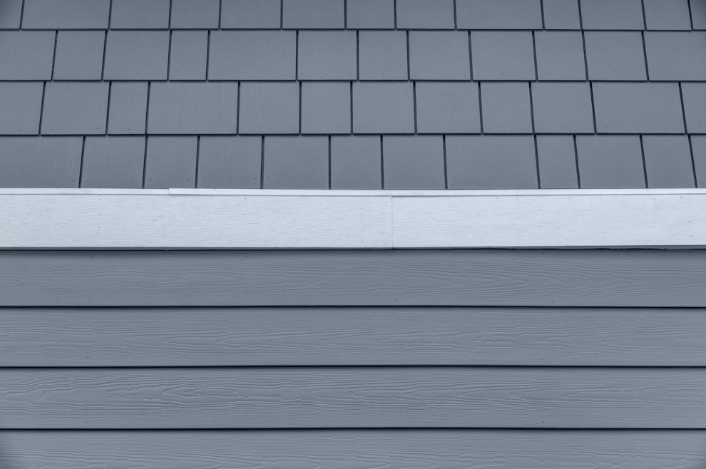 На фото: двухэтажный, синий частный загородный дом среднего размера в стиле кантри с облицовкой из ЦСП, двускатной крышей, крышей из смешанных материалов, синей крышей и отделкой планкеном