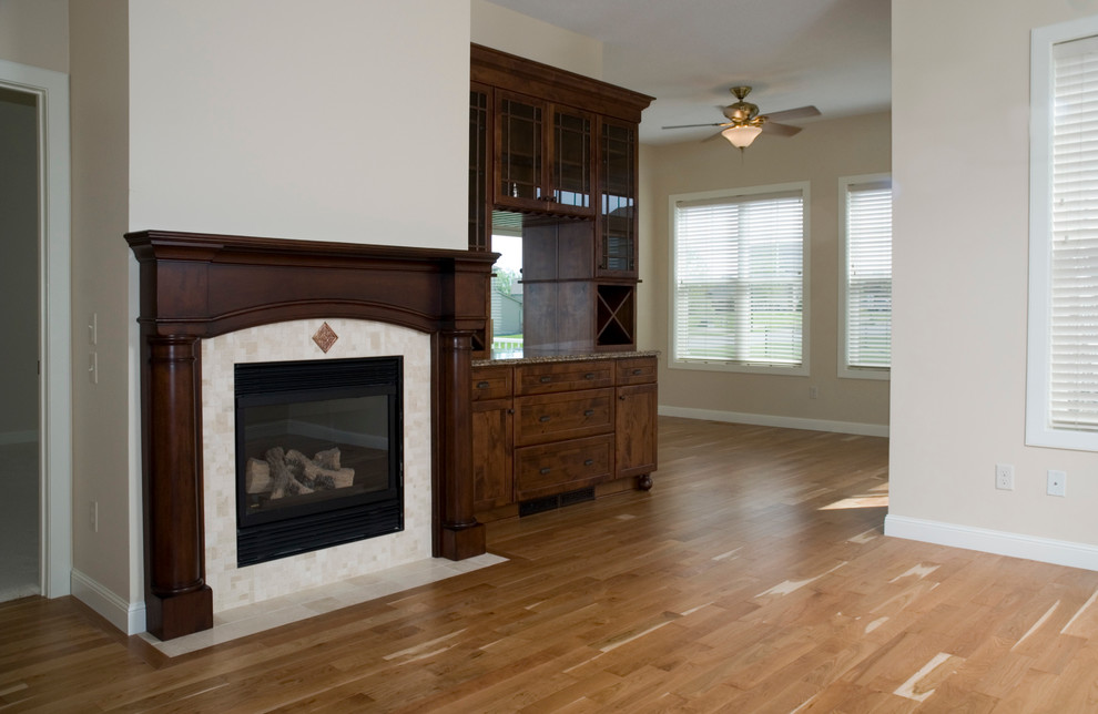 Photo of a small traditional open plan dining in Minneapolis with beige walls, medium hardwood floors, a standard fireplace and a stone fireplace surround.