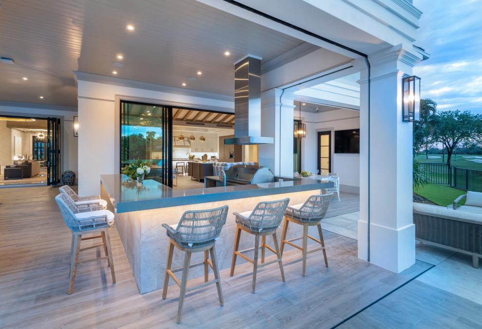 Expansive u-shaped open plan kitchen in Miami with flat-panel cabinets, white cabinets, marble benchtops, porcelain floors, with island, beige floor and white benchtop.