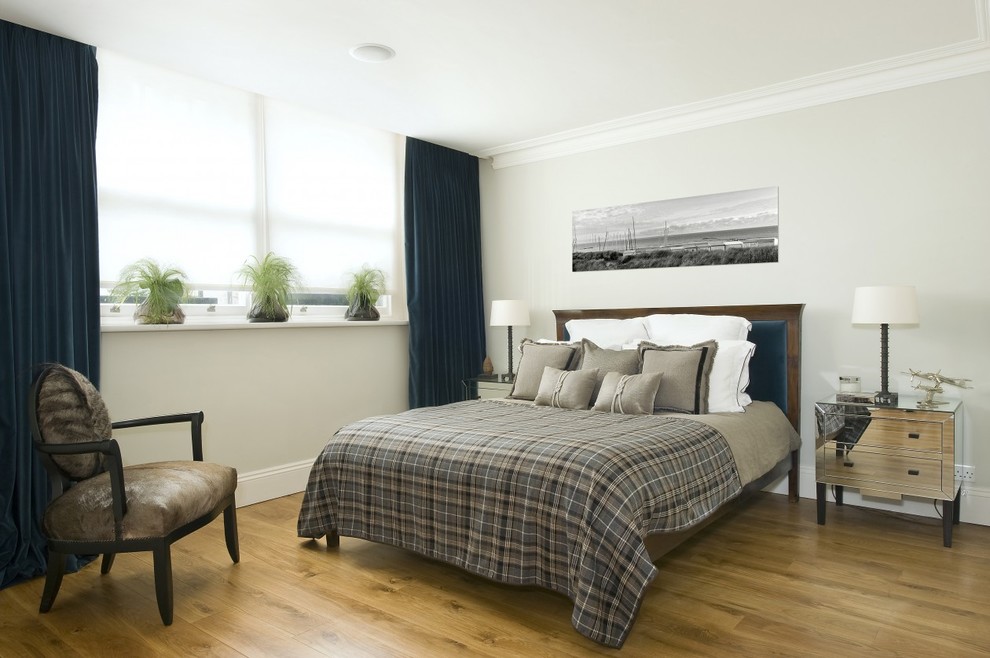 Photo of a contemporary bedroom in London with grey walls and light hardwood floors.
