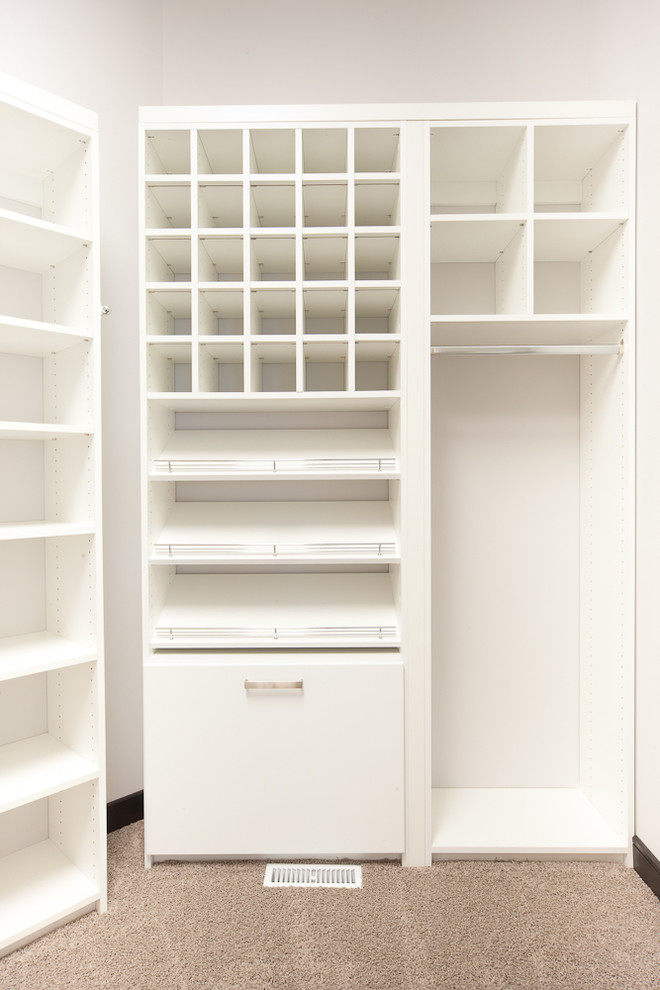 Photo of a contemporary walk-in wardrobe in Other with white cabinets and carpet.