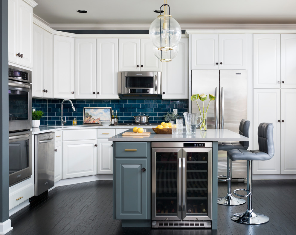 Traditional kitchen in DC Metro with raised-panel cabinets, white cabinets, blue splashback, subway tile splashback, stainless steel appliances, dark hardwood floors and with island.